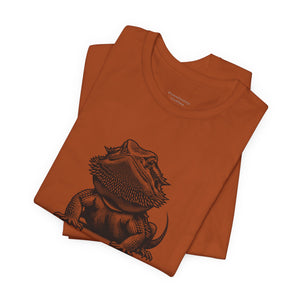 Before Coffee Bearded DragonFolded orange t-shirt with a black bearded dragon graphic on a white background