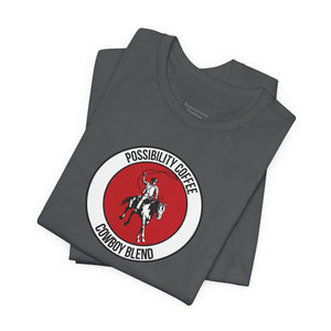 Cowboy Coffee Stack of gray t-shirts with a red and white logo featuring a cowboy on a horse.