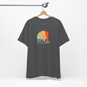 Gray t-shirt with colorful graphic and 'Full of Possibility' text on a hanger against a white background