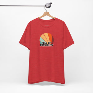 Red t-shirt with colorful graphic and 'Full of Possibility' text on a hanger against a white background