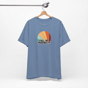 Blue t-shirt with colorful graphic and 'Full of Possibility' text on a hanger against a white background
