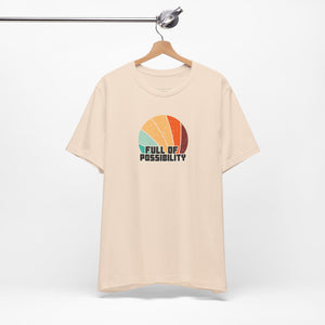 Beige t-shirt with colorful graphic and 'Full of Possibility' text on a white background