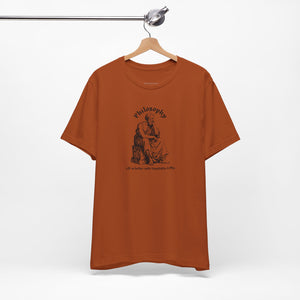 Orange t-shirt with design on a hanger against a white background