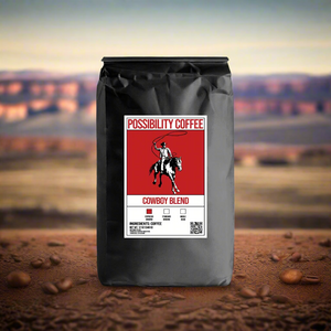 A black bag of Possibility Cowboy Blend Coffee with a western background