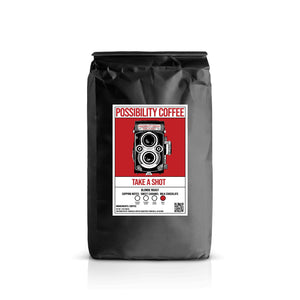 A bag of Possibility Coffee Take a Shot Blonde Espresso with Camera Image on the bag with a white background