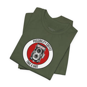 Folded green t-shirt with a red and white graphic design on a white background