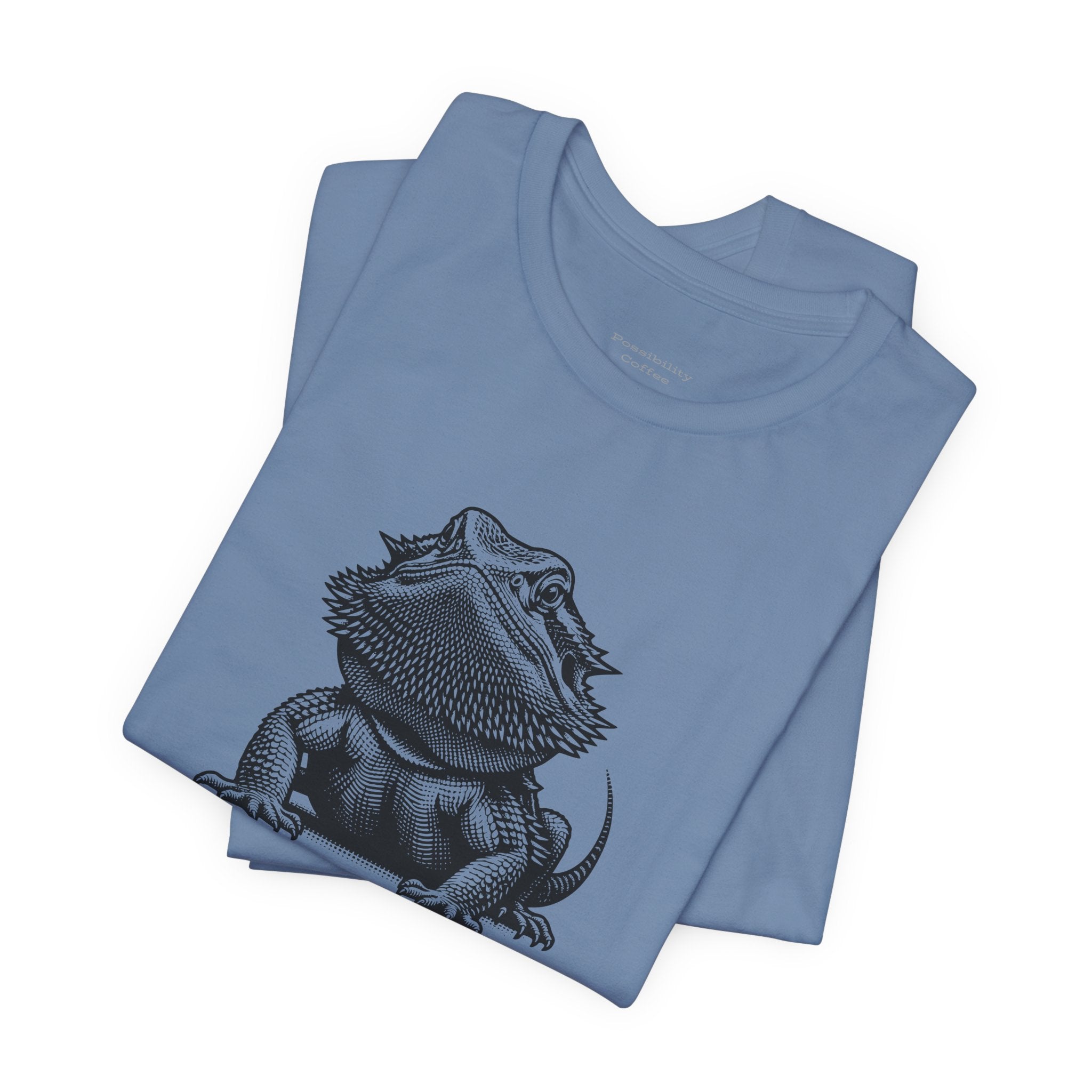 Before Coffee Bearded Dragon Folded blue t-shirt with a black bearded dragon design on a white background