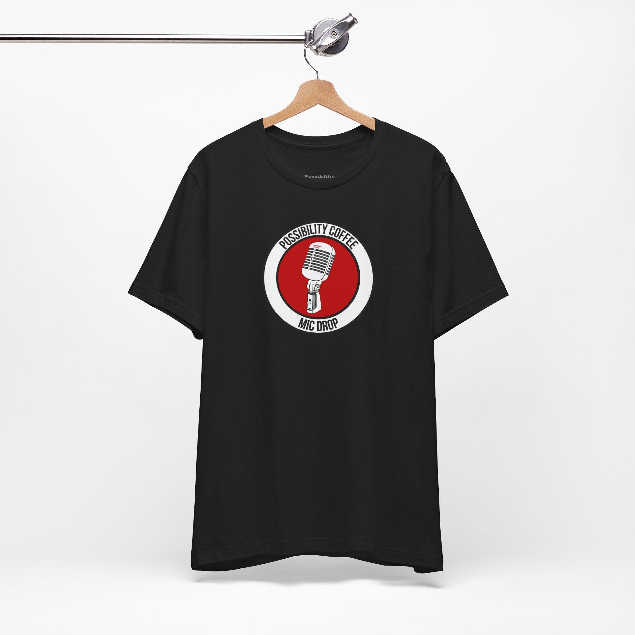 Mic Drop Black t-shirt with a red and white graphic on a hanger against a white background