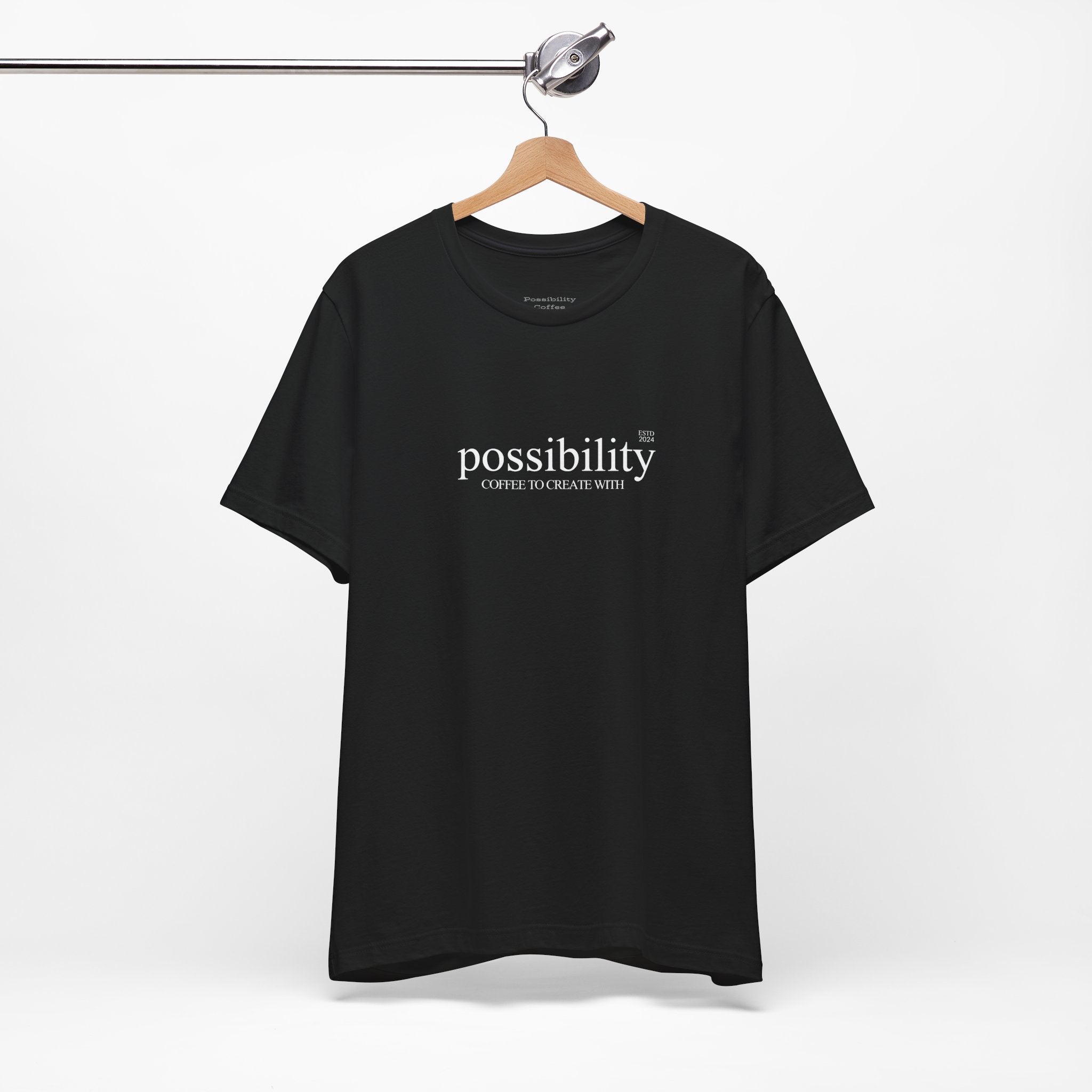 Black t-shirt with 'possibility' text on a hanger against a white background