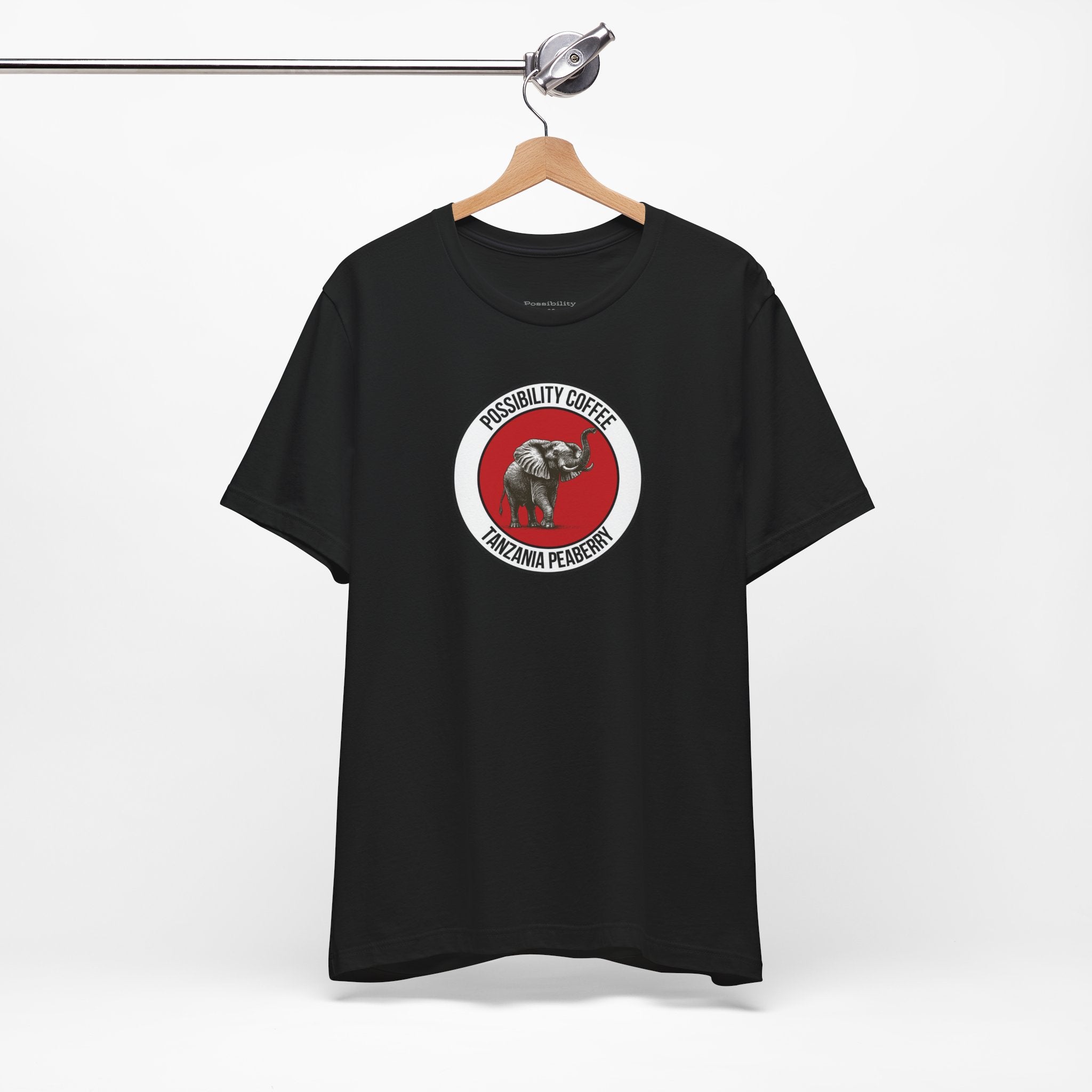 Tanzania Peaberry Black t-shirt with a red and white graphic on a hanger against a white background