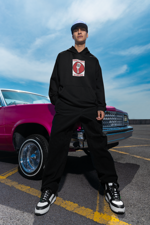 Man wearing Possibility Coffee Mic Drop Hoodie leaning next to car